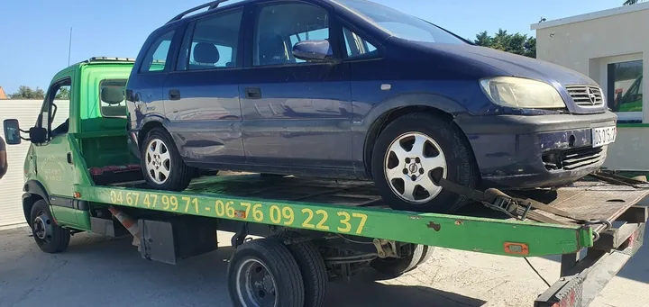 Opel Zafira avec des enfoncements latéraux sur un camion-plateau.