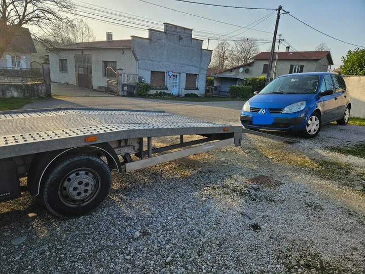 Renault Scénic au sol face au plateau vide d’une dépanneuse.