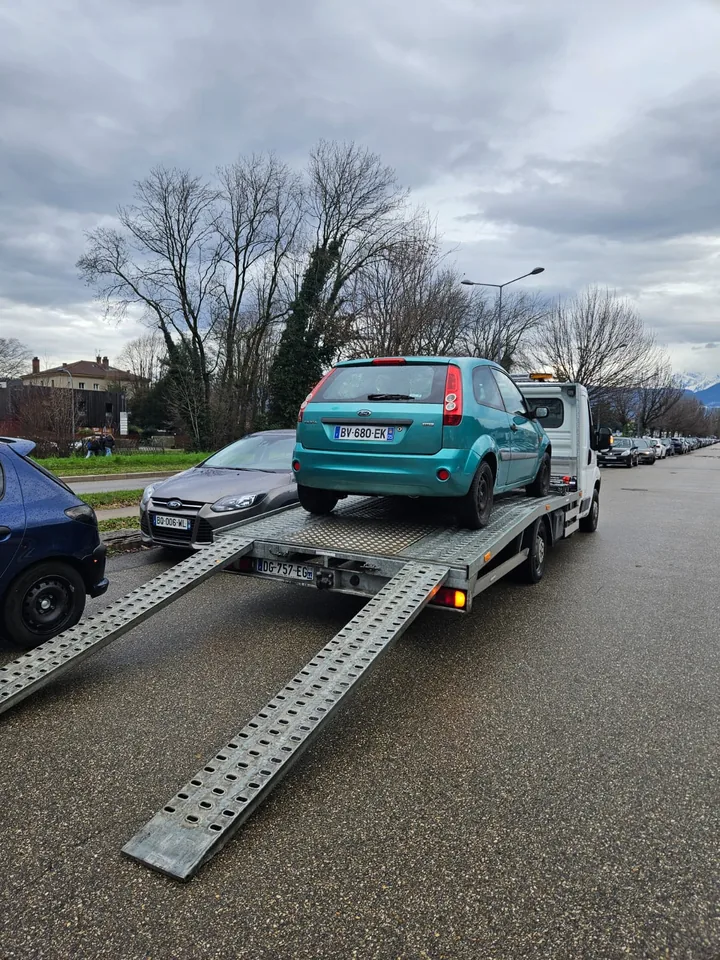 Ford Fiesta sur un camion avec deux rampes abaissées sur la chaussée.