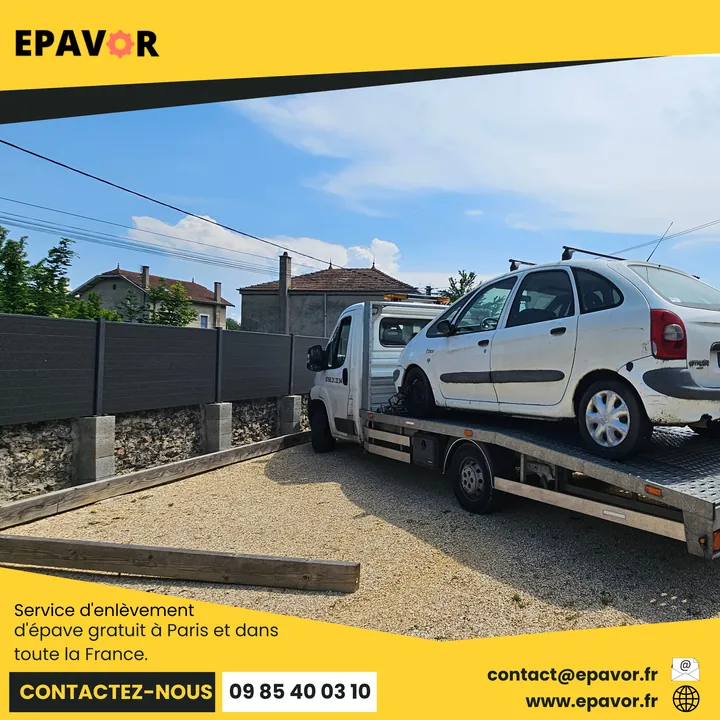 Citroën Xsara Picasso chargé sur une dépanneuse près d’un mur de clôture.