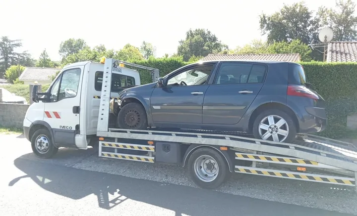 Renault Mégane à l’avant partiellement démonté sur un camion blanc.