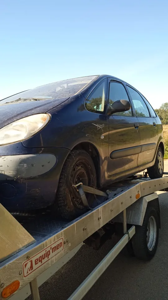Citroën Xsara Picasso sur un plateau avec une sangle à une roue avant.