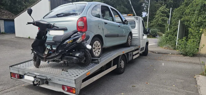 Citroën Xsara Picasso et scooter chargés ensemble sur une dépanneuse.