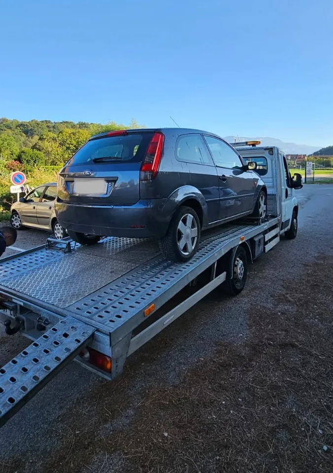 Ford Fiesta sur un plateau avec une rampe abaissée près d’un accotement.