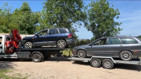 Véhicule tout terrain sur un camion plateau et break sur une remorque attelée.