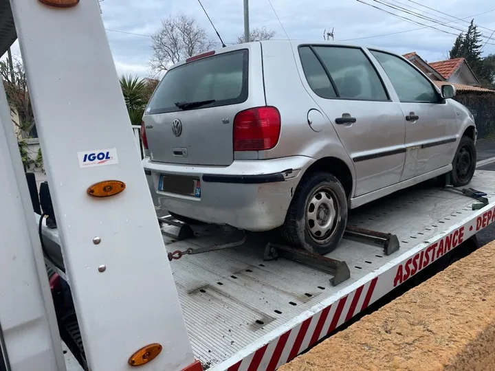 Citadine grise avec calage et matériel de maintien au niveau des roues sur plateau.