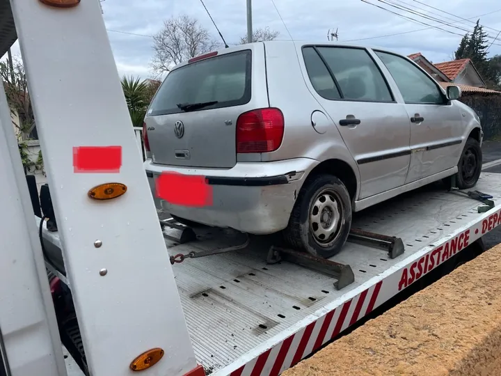 Citadine grise posée sur plateau avec des éléments de calage près des roues.