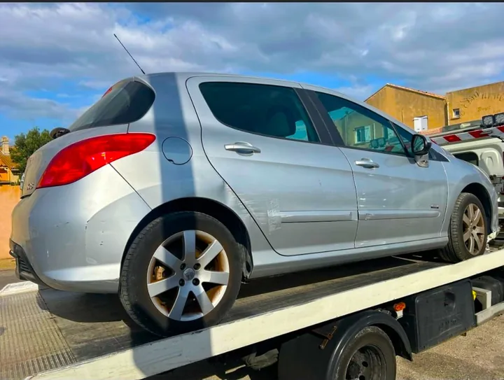 Voiture grise à cinq portes installée sur la plateforme d’un camion.