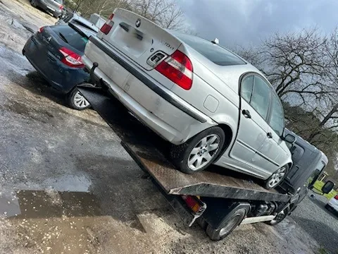 Berline claire à quatre portes chargée sur un camion plateau.