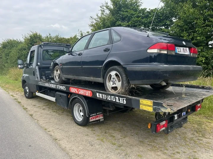 Berline sombre chargée sur le plateau d’une dépanneuse.