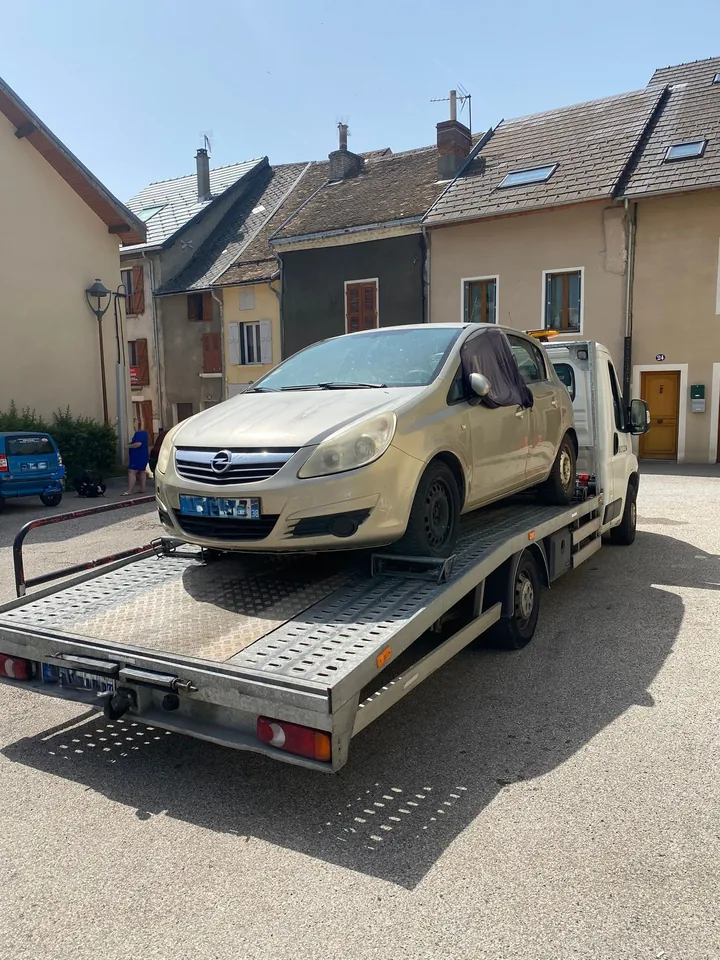 Citadine claire avec une protection sur une vitre latérale et des cales près des roues.