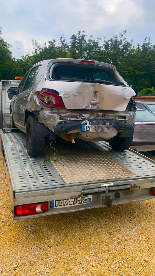 Arrière écrasé d’une voiture claire chargée sur une dépanneuse.